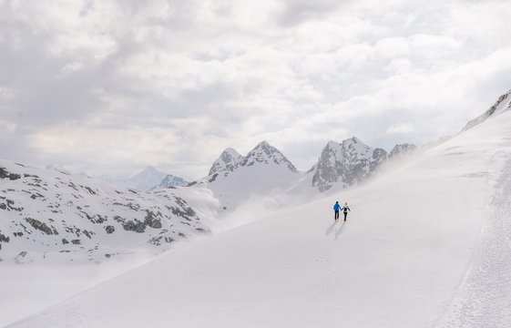 Mann und Frau machen eine Winterwanderung mit traumhaften Bergpanorama.