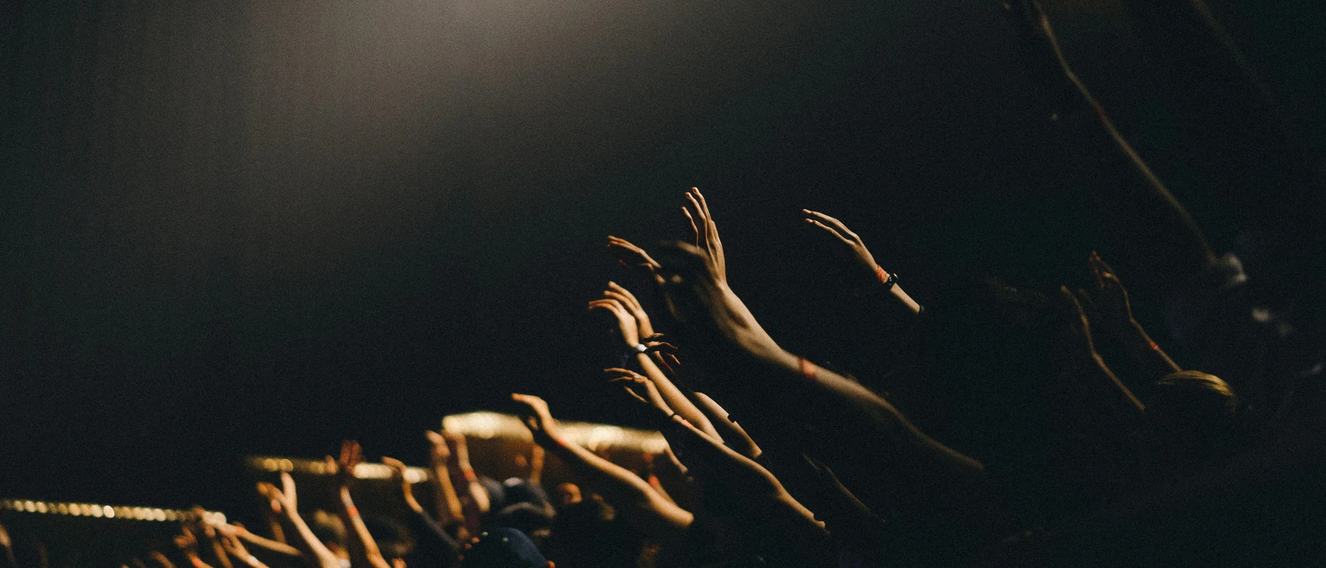 Culture and events in Lech am Arlberg People raising hands in dark room with beam of light