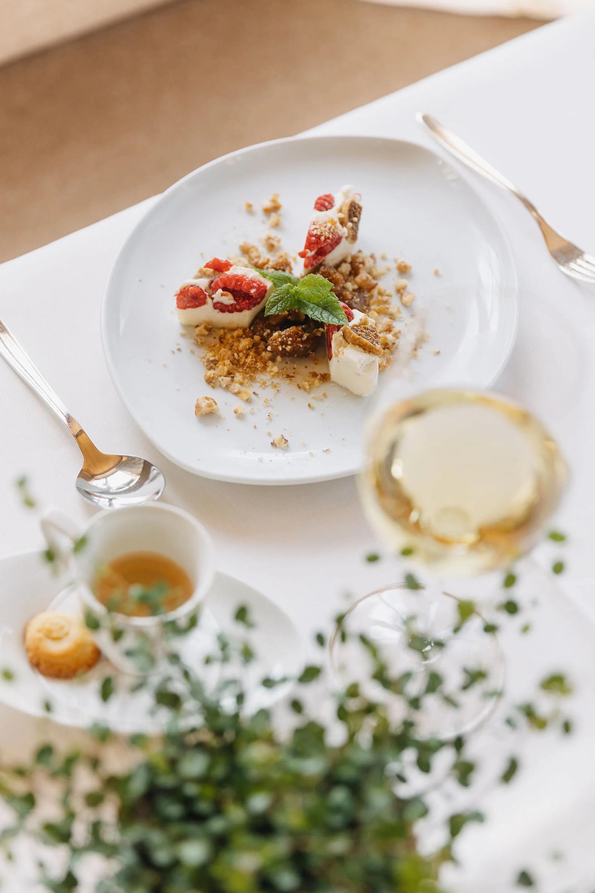 Aurora, Ihr Hotel in Lech am Arlberg Kleiner Nachtisch mit Beeren, Keksen und Minzblatt auf weißem Teller