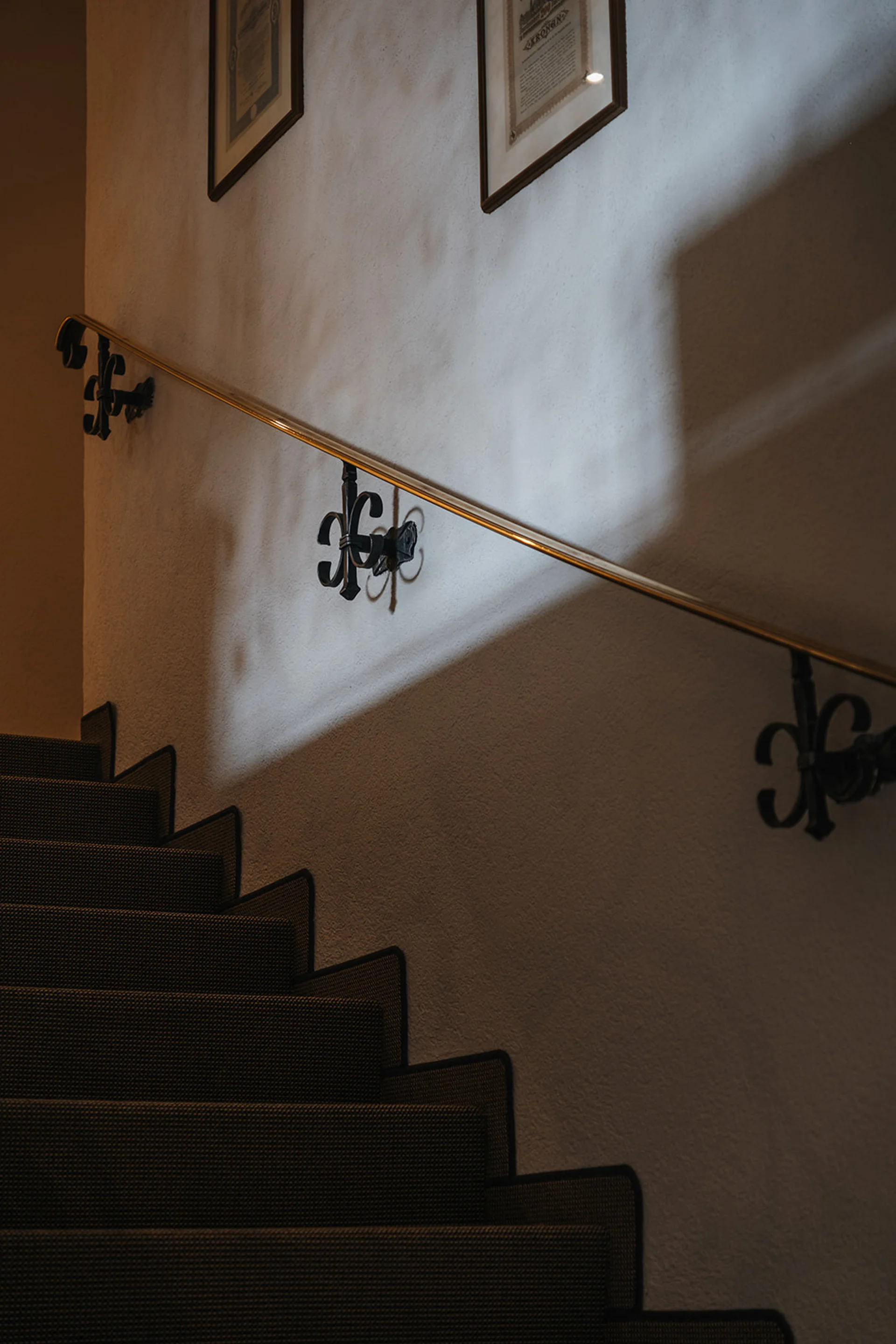 Aurora, Ihr Hotel in Lech am Arlberg Dunkle Treppe mit Teppichläufer und beleuchtetem Handlauf an der Wand