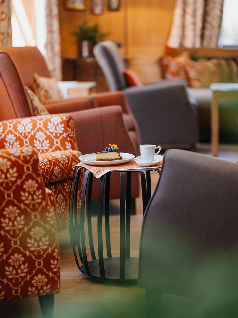 Aurora, Ihr Hotel in Lech am Arlberg Gemütlicher Sitzbereich mit Tasse und Stück Kuchen auf kleinem Tisch