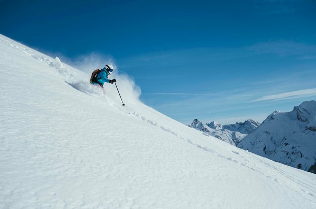 Ein Skifahrer macht einen Abfahrt im Tiefschnee