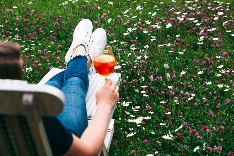 Frau chillt im Garten mit Cocktail