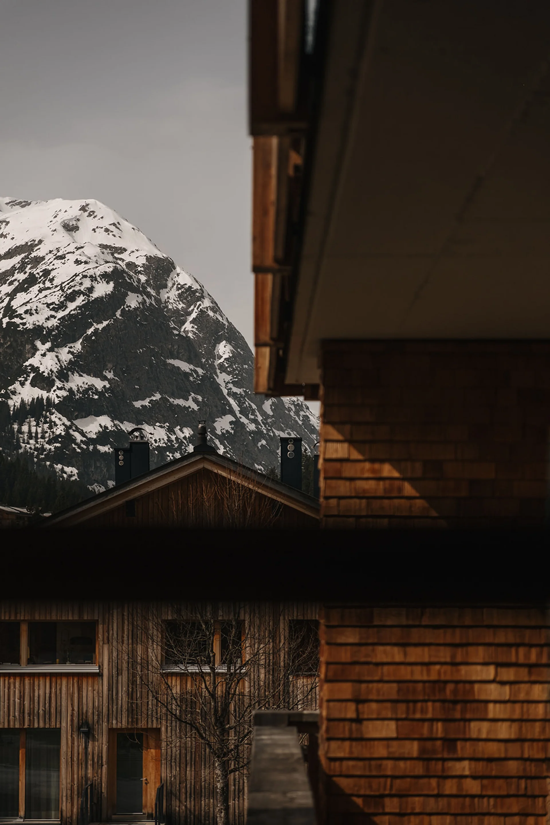 Aurora, Ihr Hotel in Lech am Arlberg Holzhäuser vor schneebedecktem Berg im ruhigen Dorf